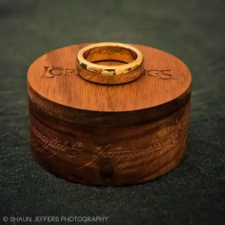 Jens Hansen gold plated tungsten One Ring resting on its walnut box