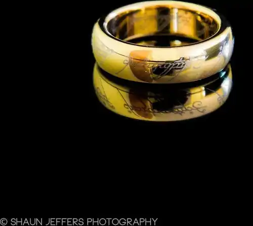 Jens Hansen gold plated tungsten One Ring reflected on a black surface